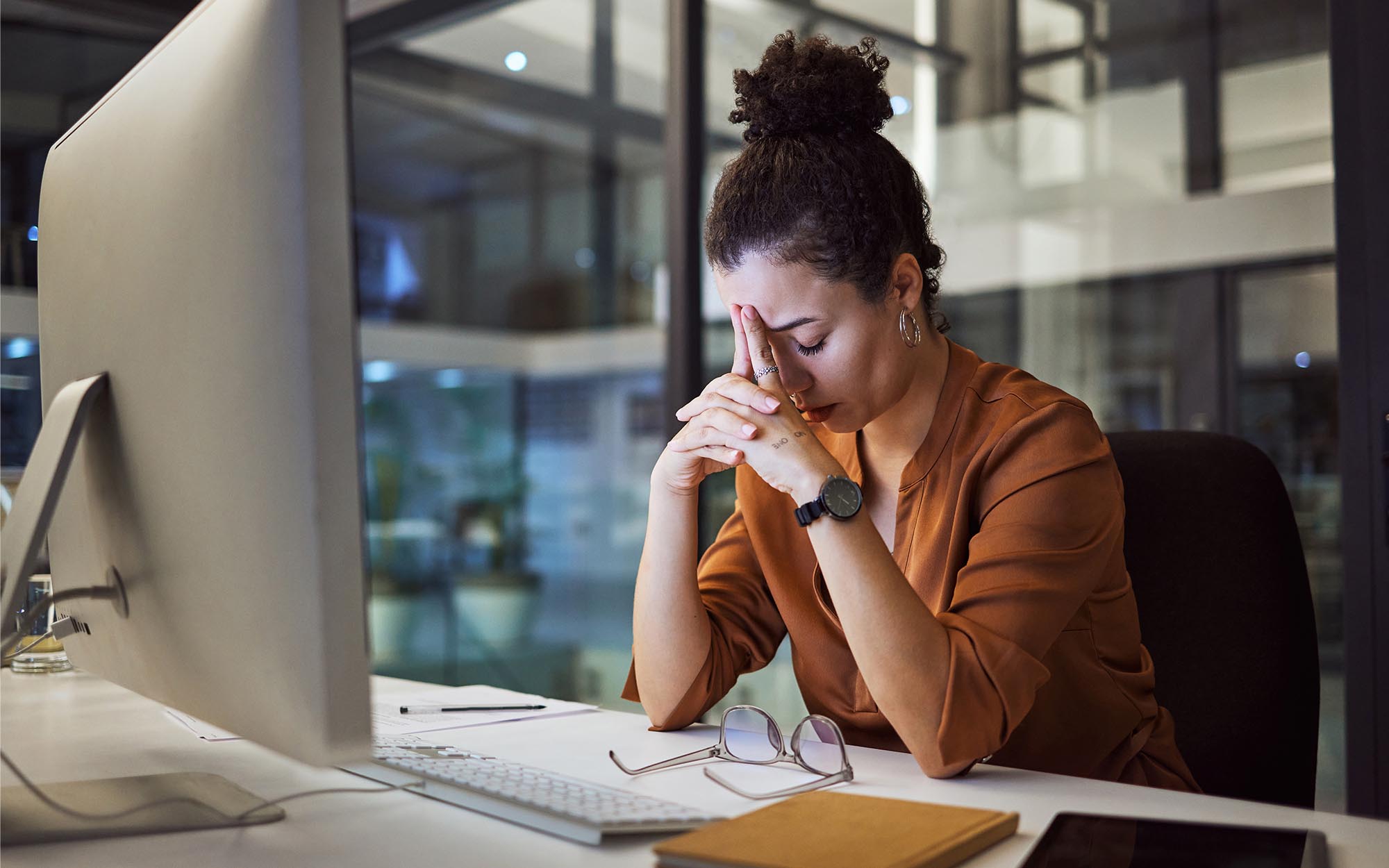 Image of a stressed out person sitting at their computer desk.